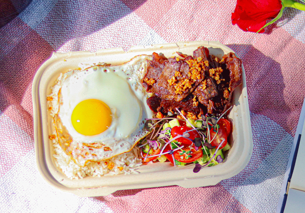 Tapsilog, a traditional Filipinon dish with beef, an overeasy egg, pickled vegetables, and garlic fried rice.