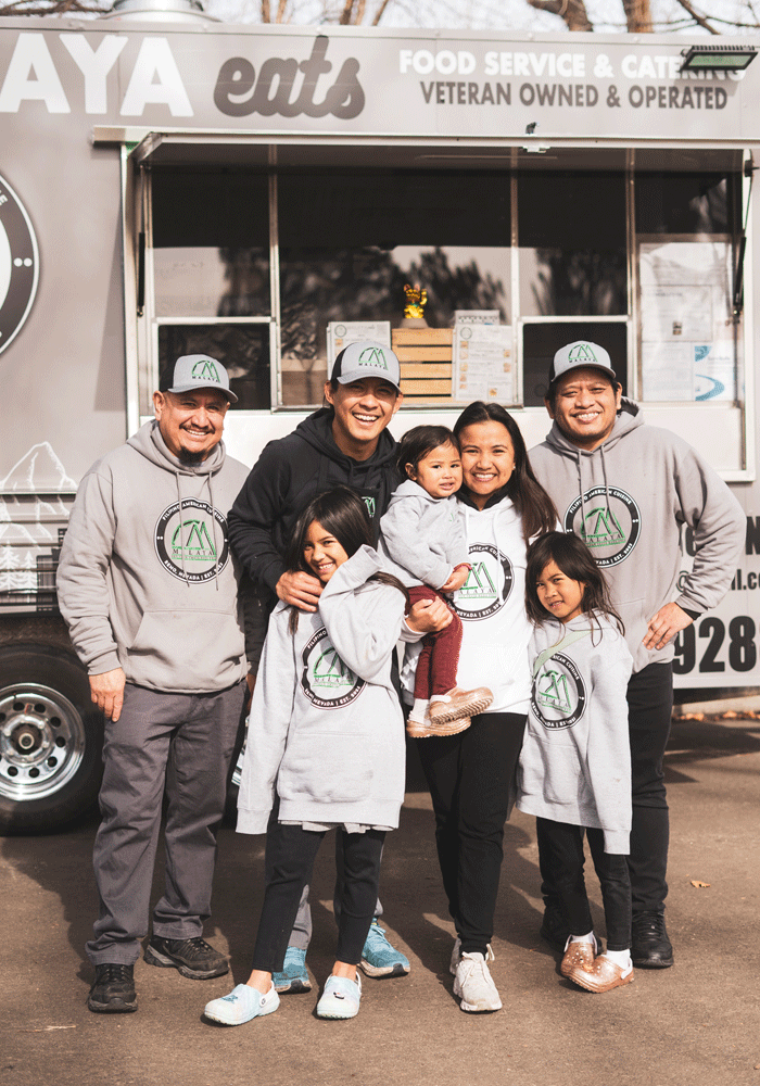 The Malaya Eats family and team poses together smiling in front of their food truck.