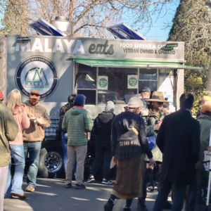 Malaya Food truck on a sunnday day with a crowd of people waiting in line.